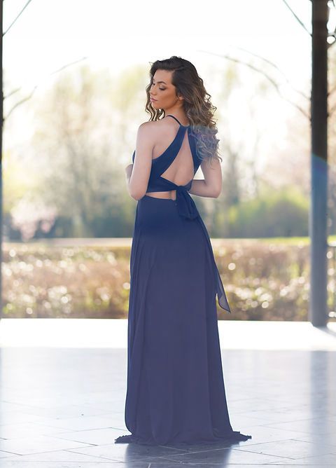 Vestido Jamaica Modelo de costas usando vestido longo azul escuro com alças cruzadas