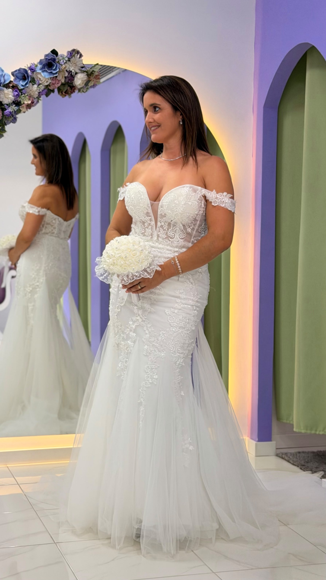 Vestido Wedding Ilusion Mulher com vestido de noiva branco com renda e bouquet branco, refletida em espelho decorado com flores