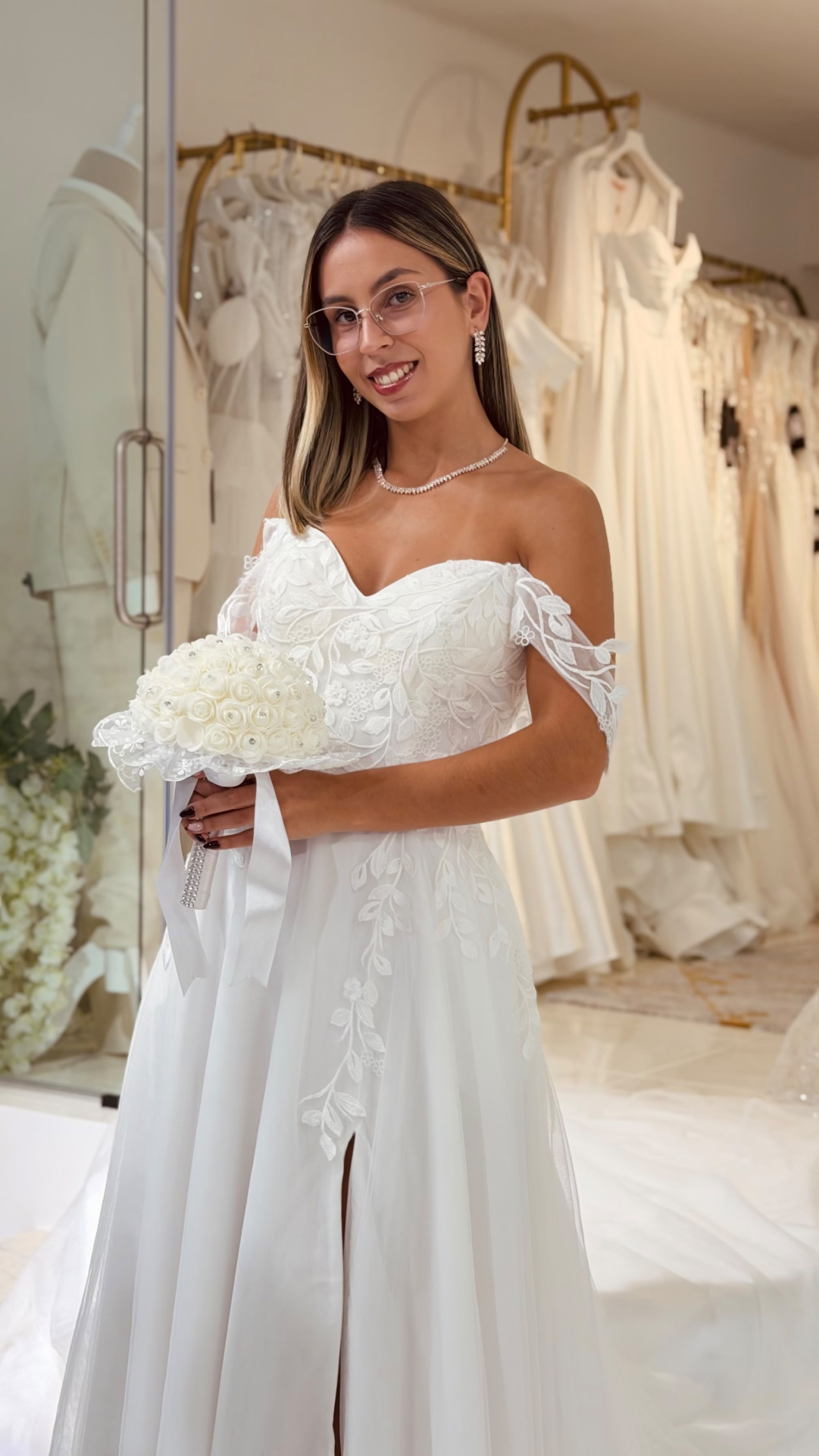 Vestido Amarílis Mulher com vestido de noiva branco e bouquet em loja de vestidos de casamento