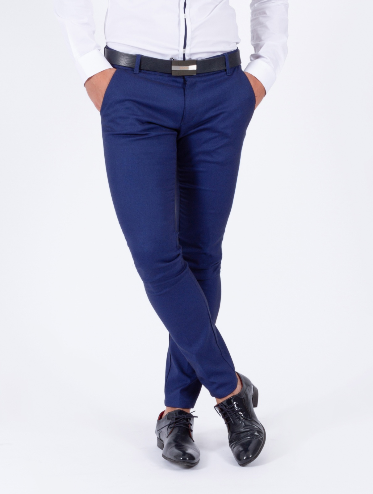 CALÇA SMK BLUE REFLECTION Homem com calças azuis, camisa branca, cinto preto e sapatos pretos