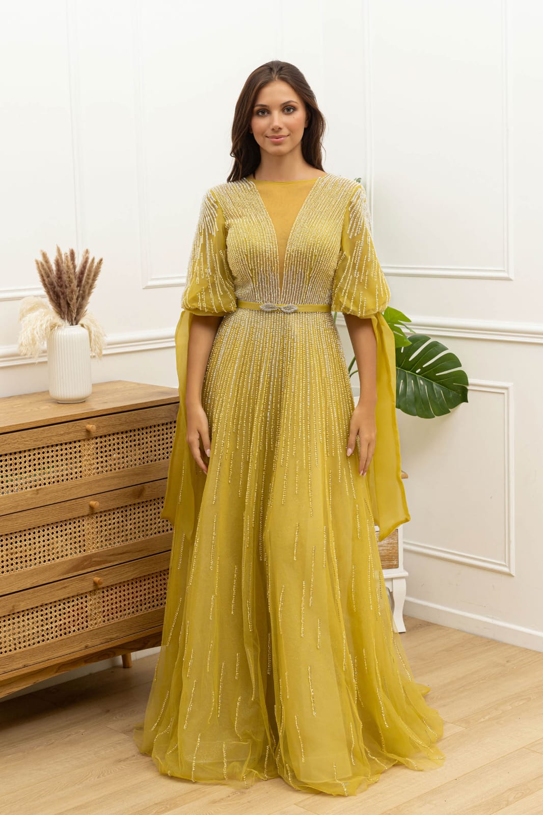Vestido Solenna Vestido longo amarelo com tule e lantejoulas prateadas em ambiente interior