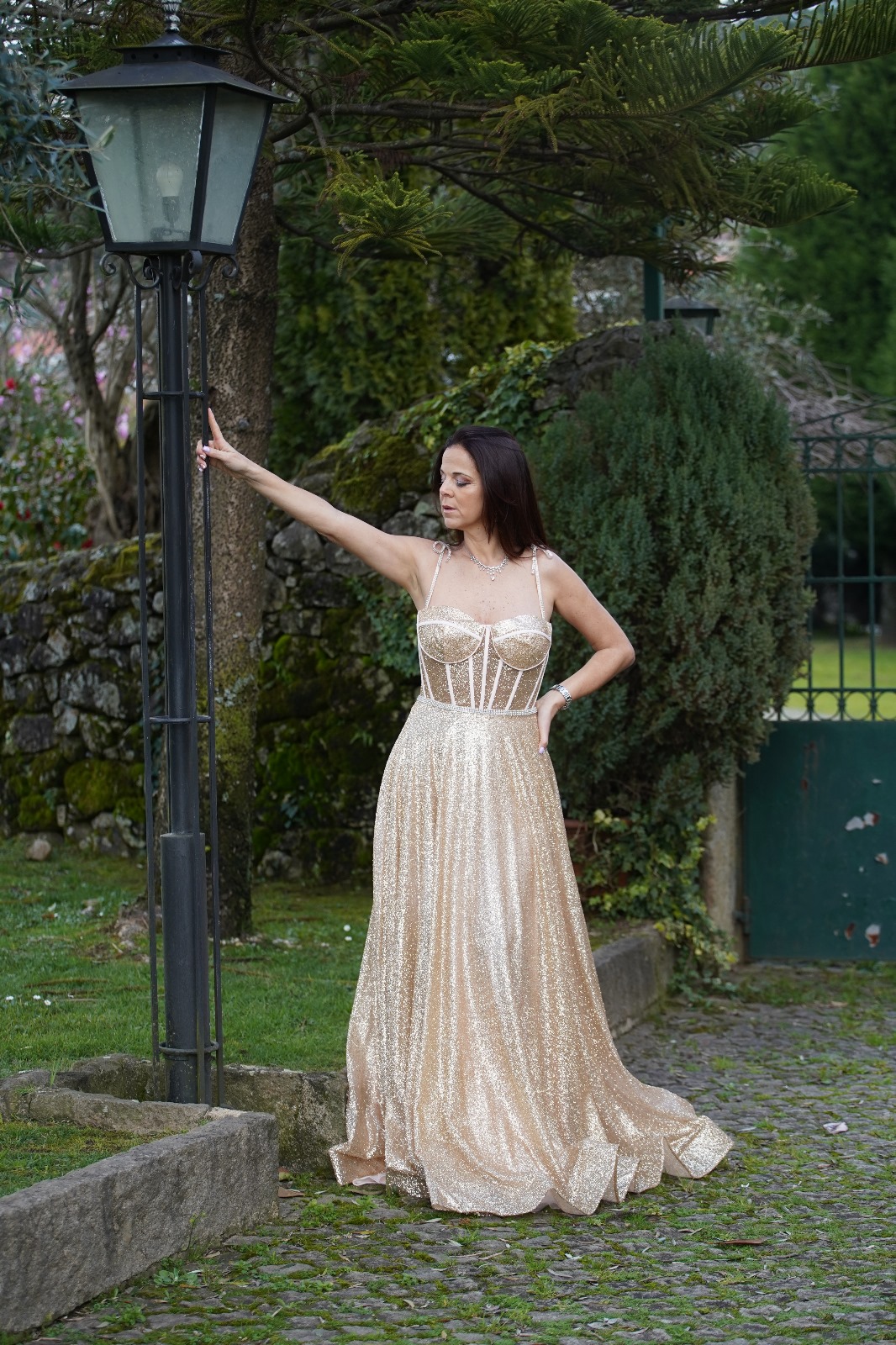 Vestido Princess Glow Vestido longo dourado brilhante com corpete estruturado e alças finas em ambiente exterior