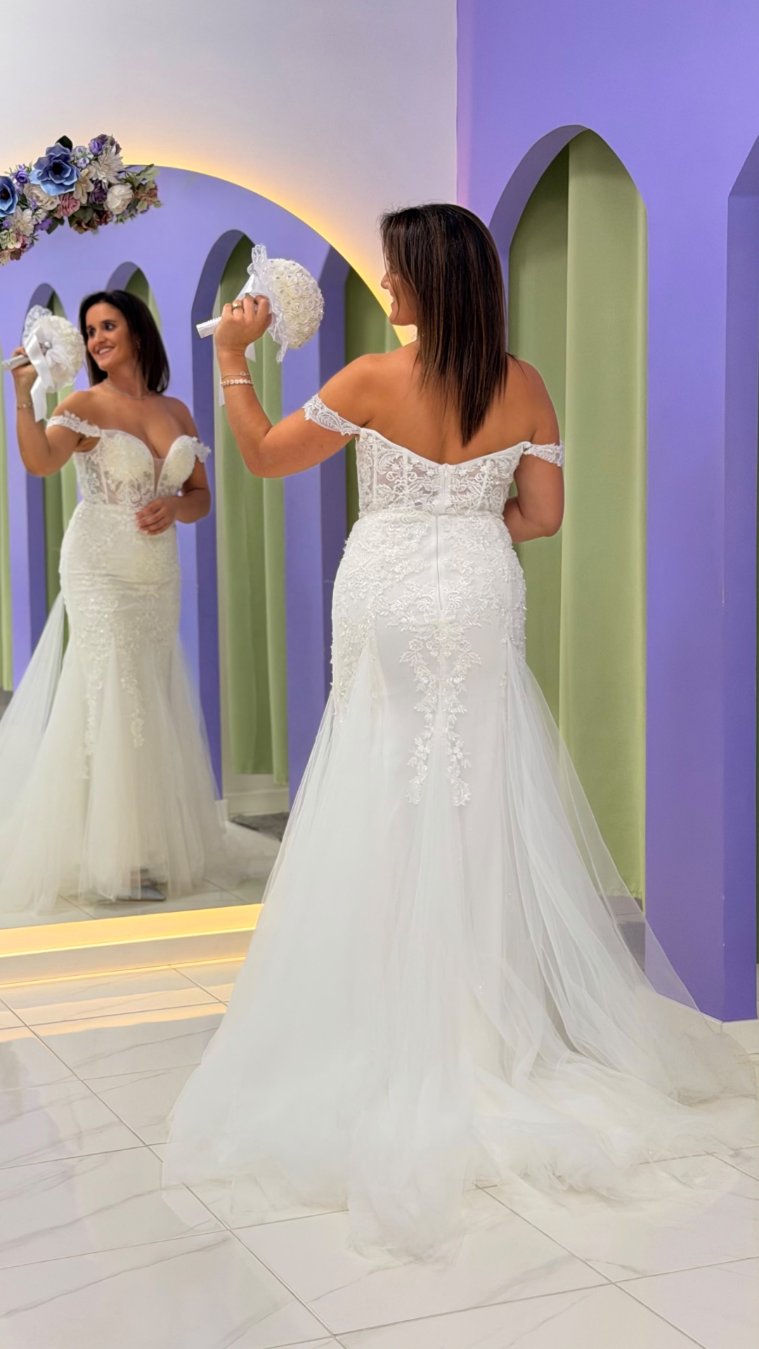 Vestido Wedding Ilusion Vestido de noiva branco com rendas e tule e decote ombro a ombro, refletido num espelho