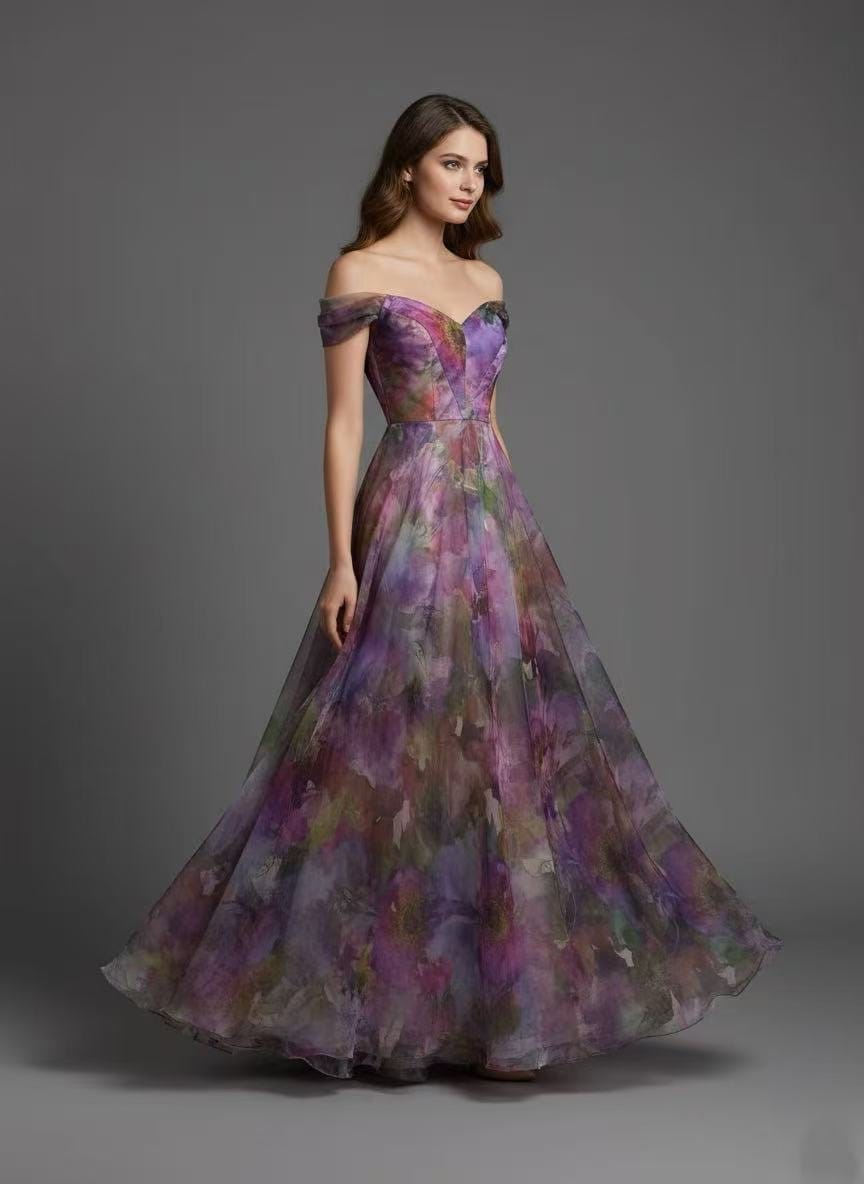 Vestido Elodie Vestido longo floral com decote ombro a ombro e saia esvoaçante em tons roxos e verdes.