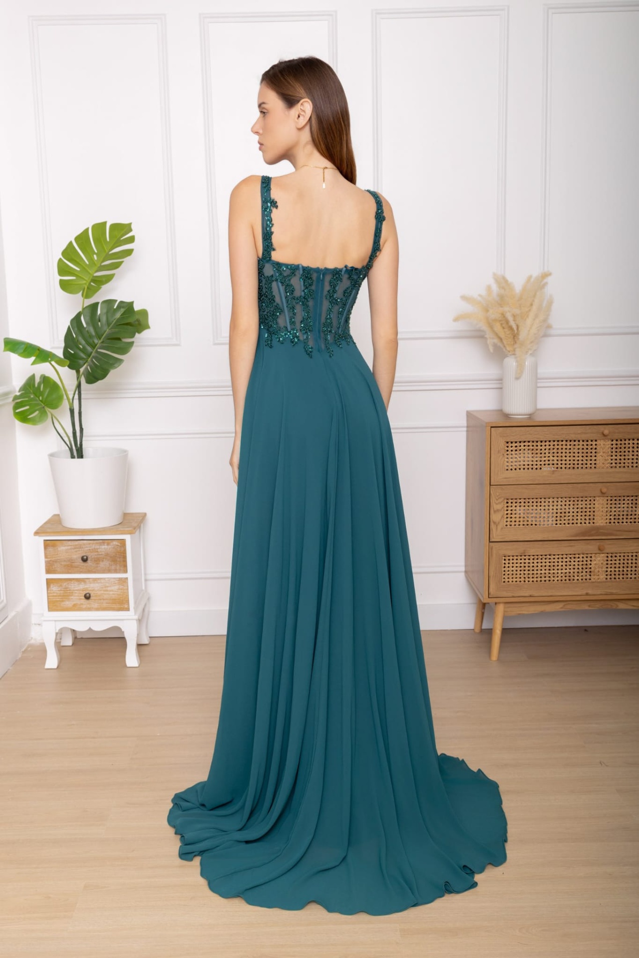 Vestido Brasil Vestido longo azul esverdeado com bordados e corpet transparente visto de costas.