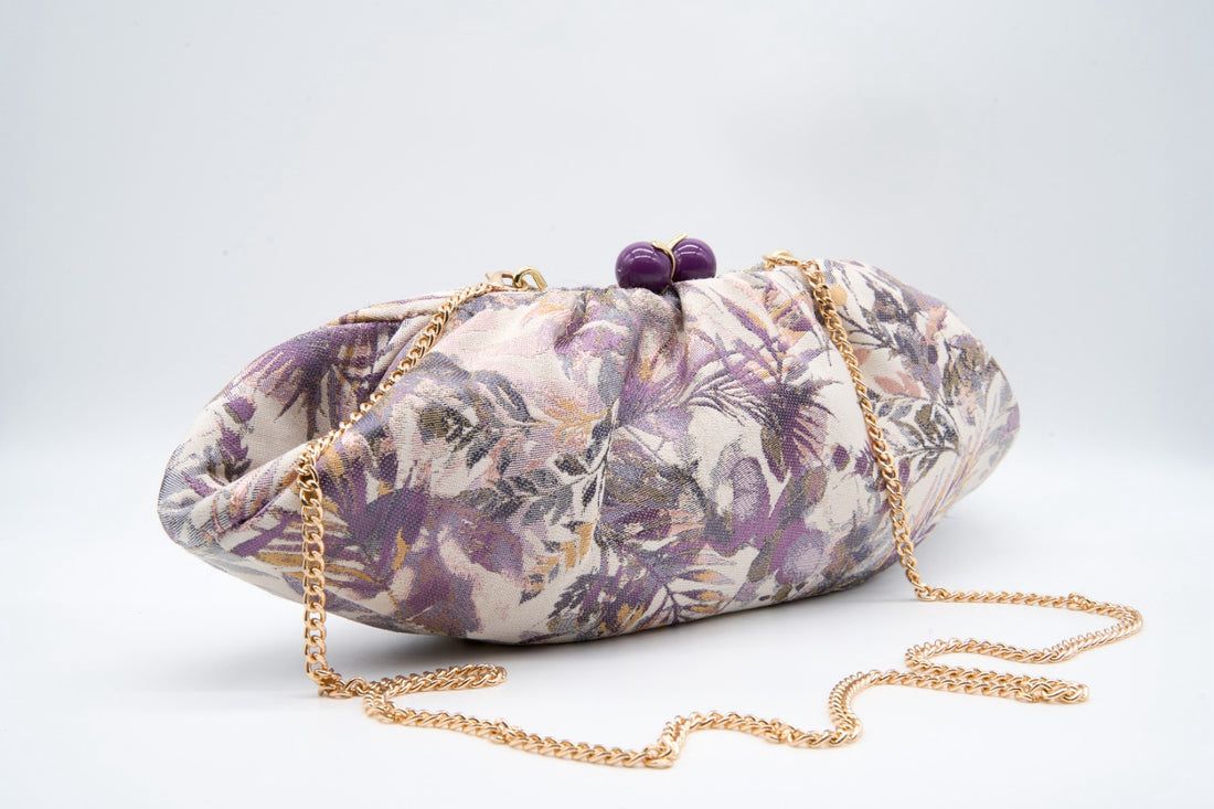 Pochete Tons Lilás Mala de mão floral com corrente dourada sobre fundo branco