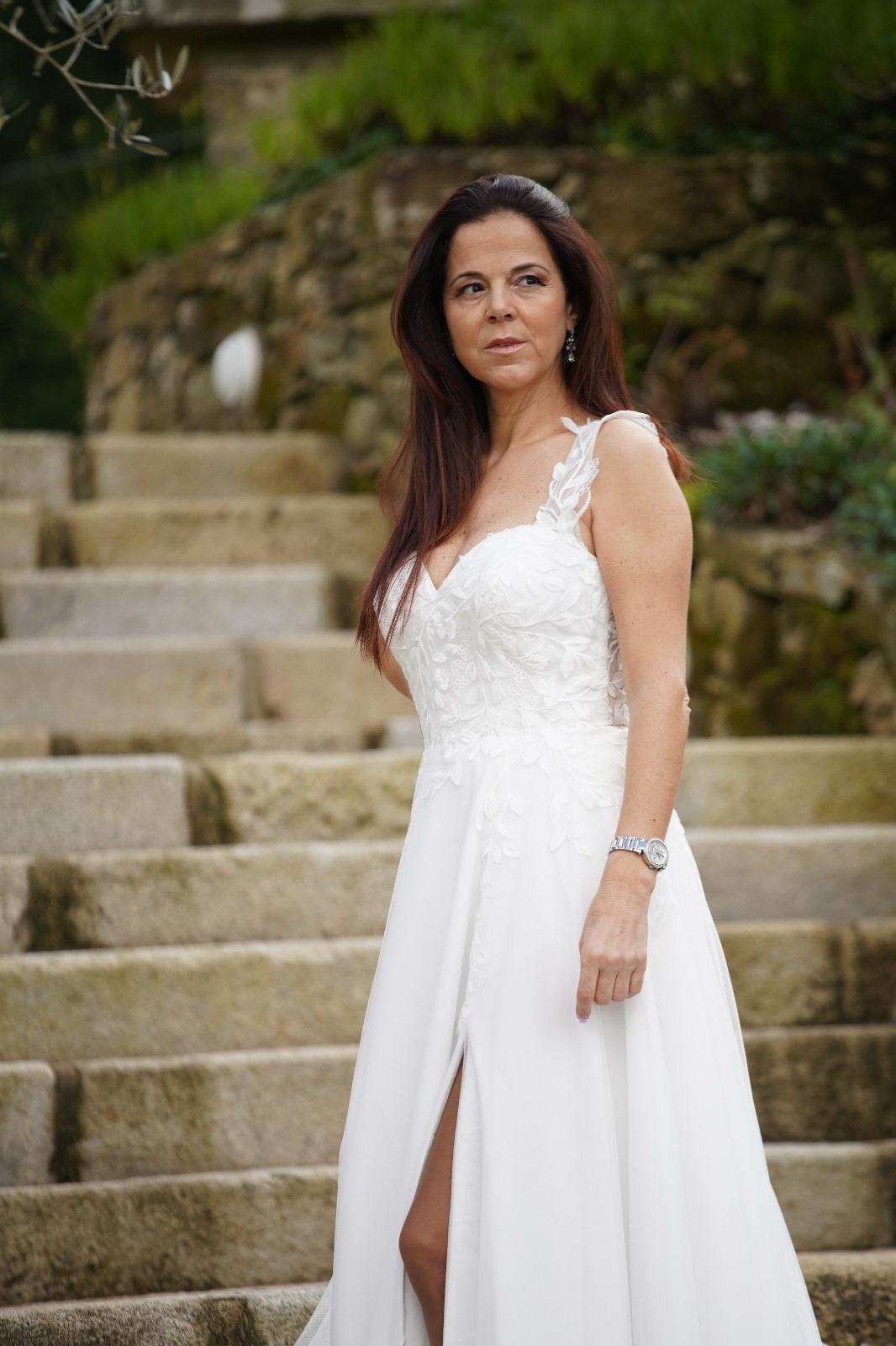 Vestido Amarílis Mulher com vestido de noiva branco posando em escadaria de pedra