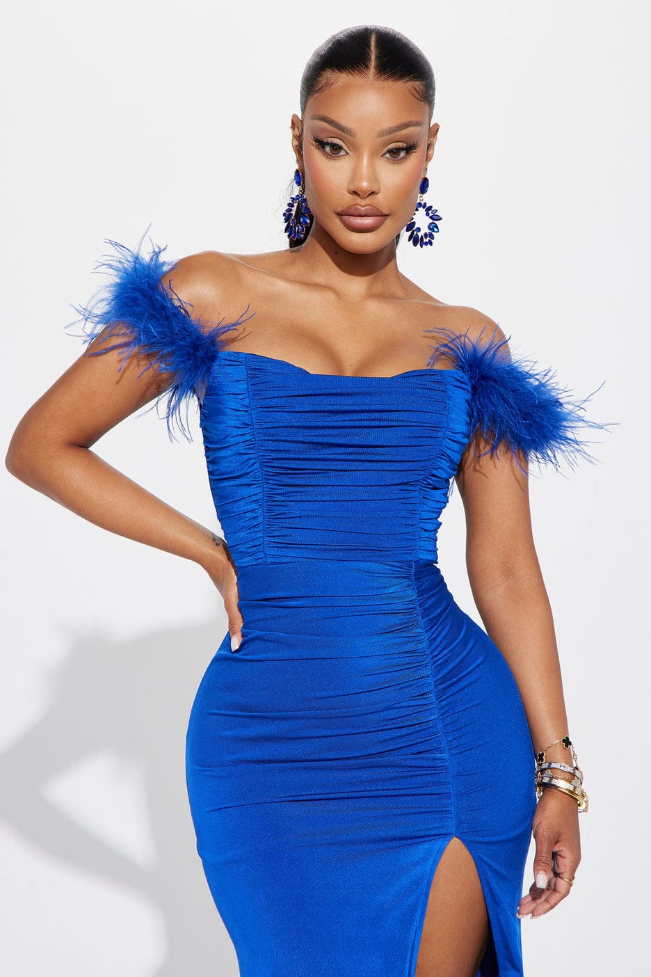 Vestido Valquíria Vestido azul justo com ombros com penas, racha frontal, usado por mulher em fundo branco