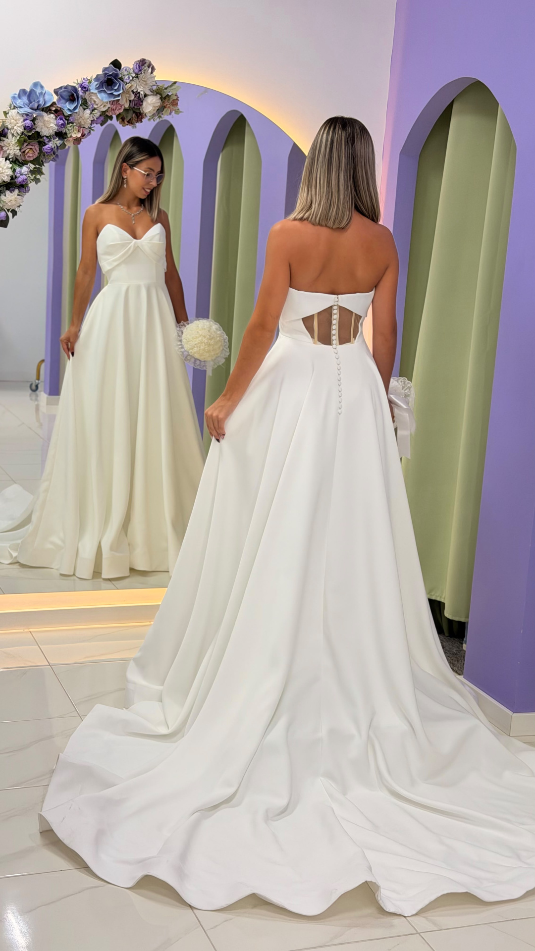 Vestido Celine Noiva Vestido de noiva branco com saia ampla e corpete tomara que caia em loja com decoração lilás