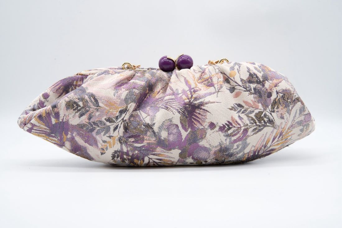 Pochete Tons Lilás Bolsa de tecido floral com fecho roxo em fundo branco