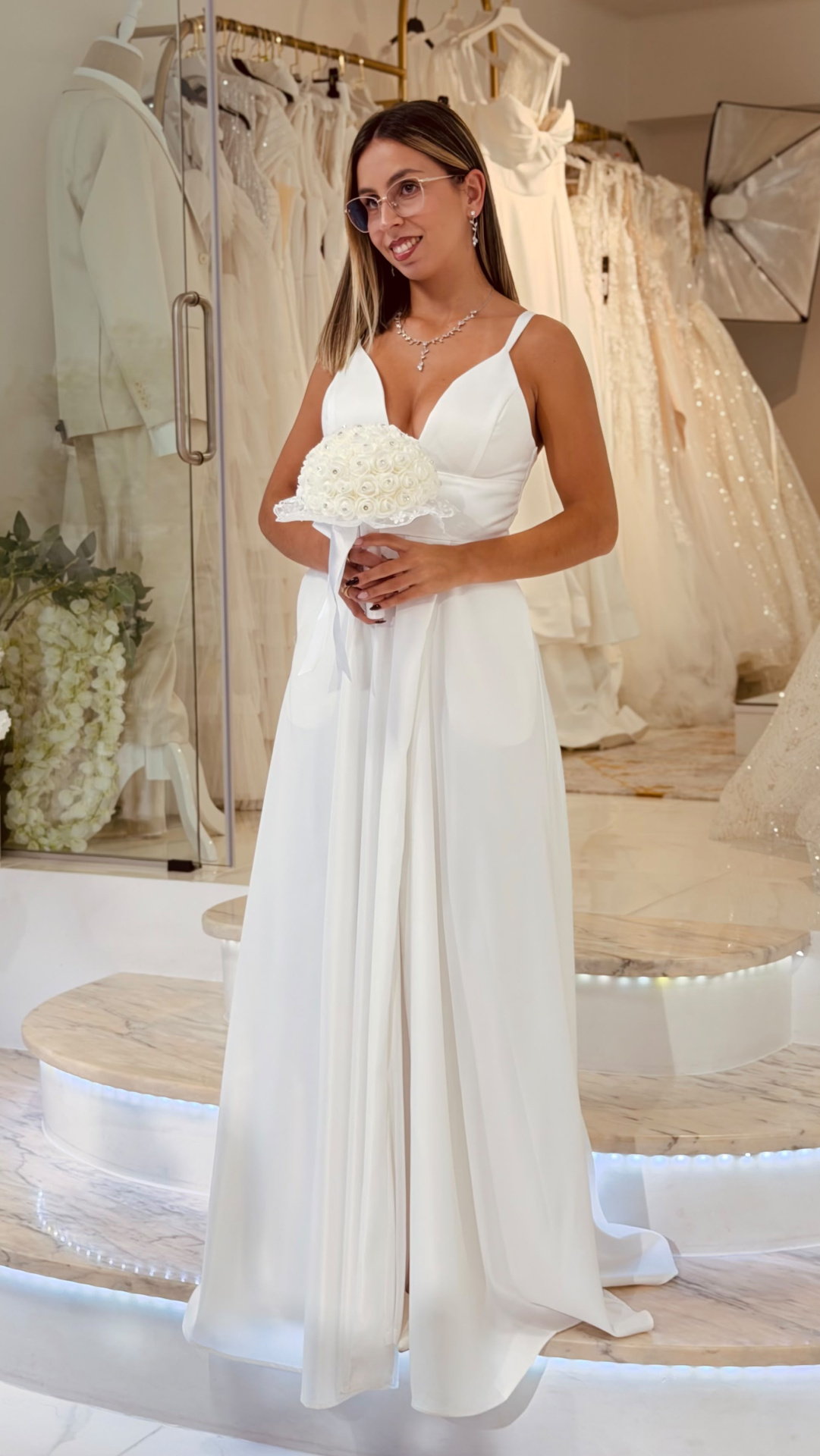 Vestido Muse Noiva Mulher com vestido branco de noiva e bouquet em loja de vestidos de casamento