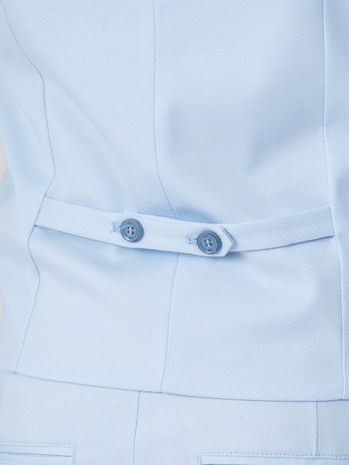 Colete SMK Azul Claro Detalhe de casaco azul claro com cinto decorativo e botões