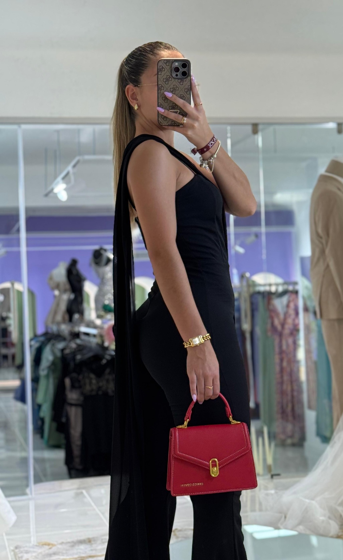 Macacão ERK c/ Echarpe Mulher com macacão preto e mala vermelha ENRICO COVERI em loja de roupas