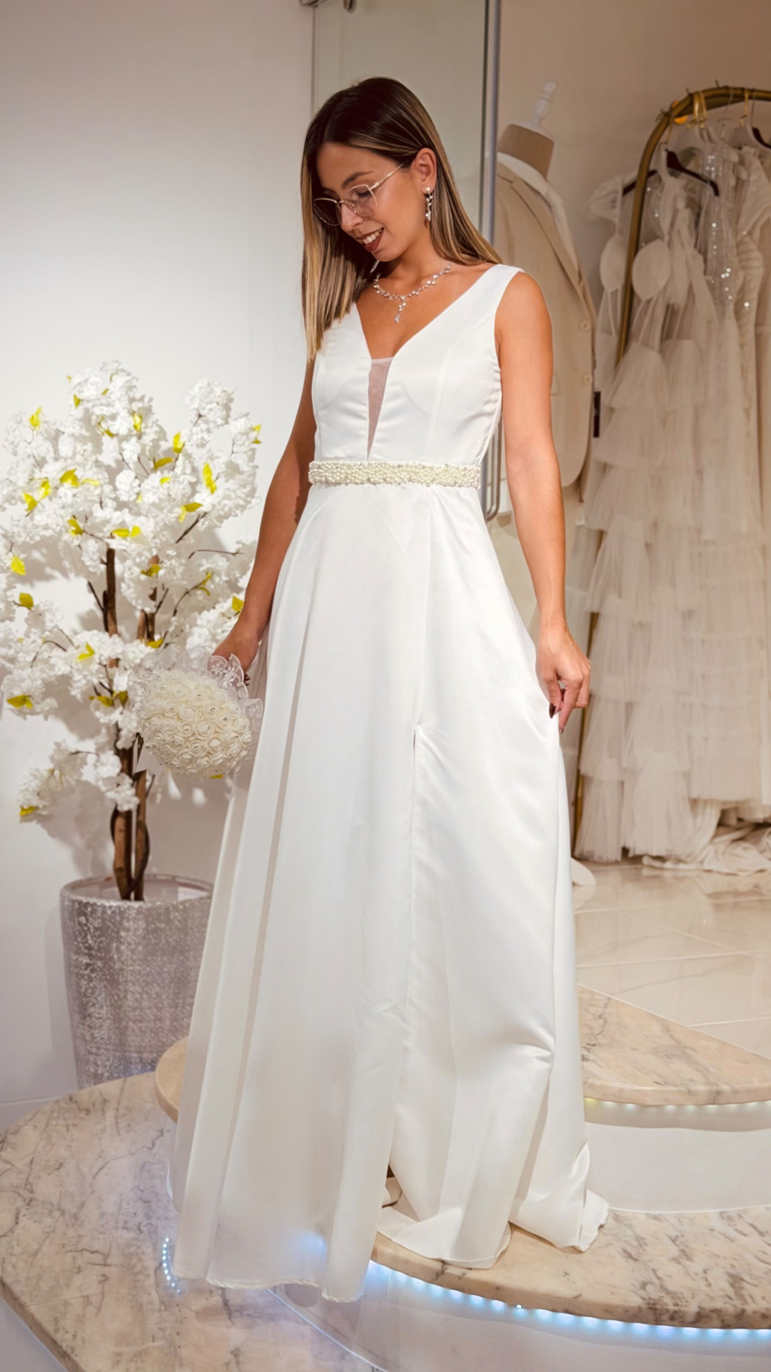 Vestido Glace Noiva Mulher a usar vestido de noiva branco com decote em V e cinto de pérolas