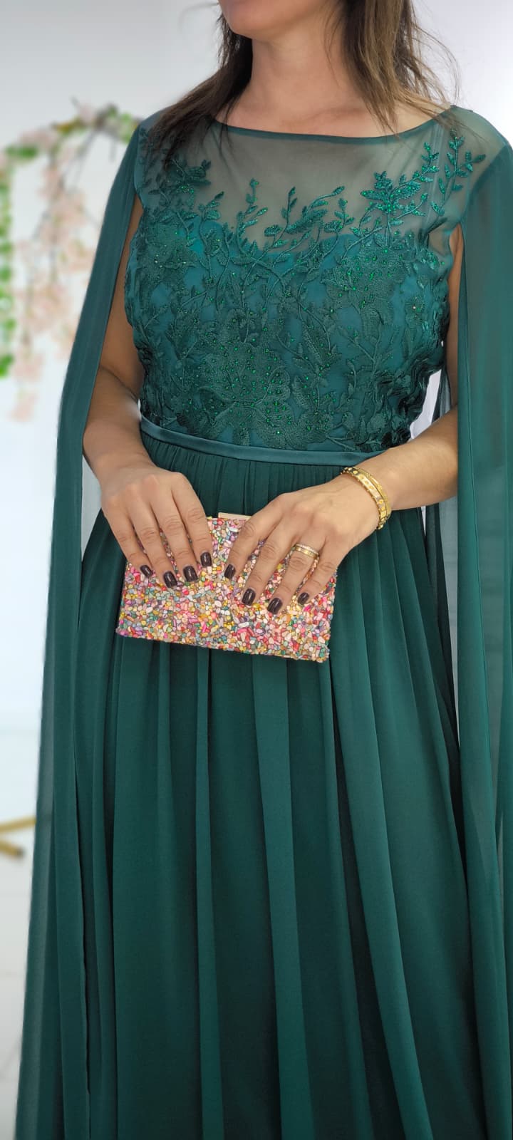 Vestido Cleopatra Plus Size Vestido verde com bordados e transparência segurando carteira colorida
