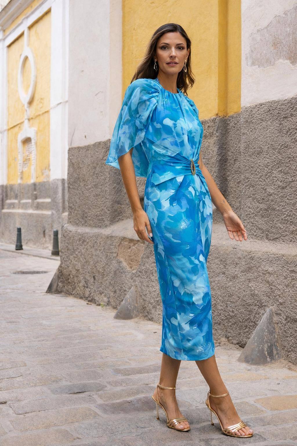Vestido Dolcezza Petals Vestido midi azul com padrão abstrato, cinto com fivela e salto alto dourado numa rua.
