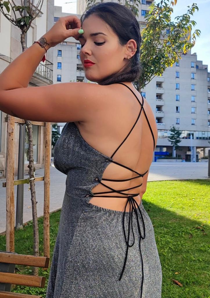 Vestido c/atilhos costas brilhante Vestido cinza prateado com alças pretas cruzadas nas costas em ambiente urbano