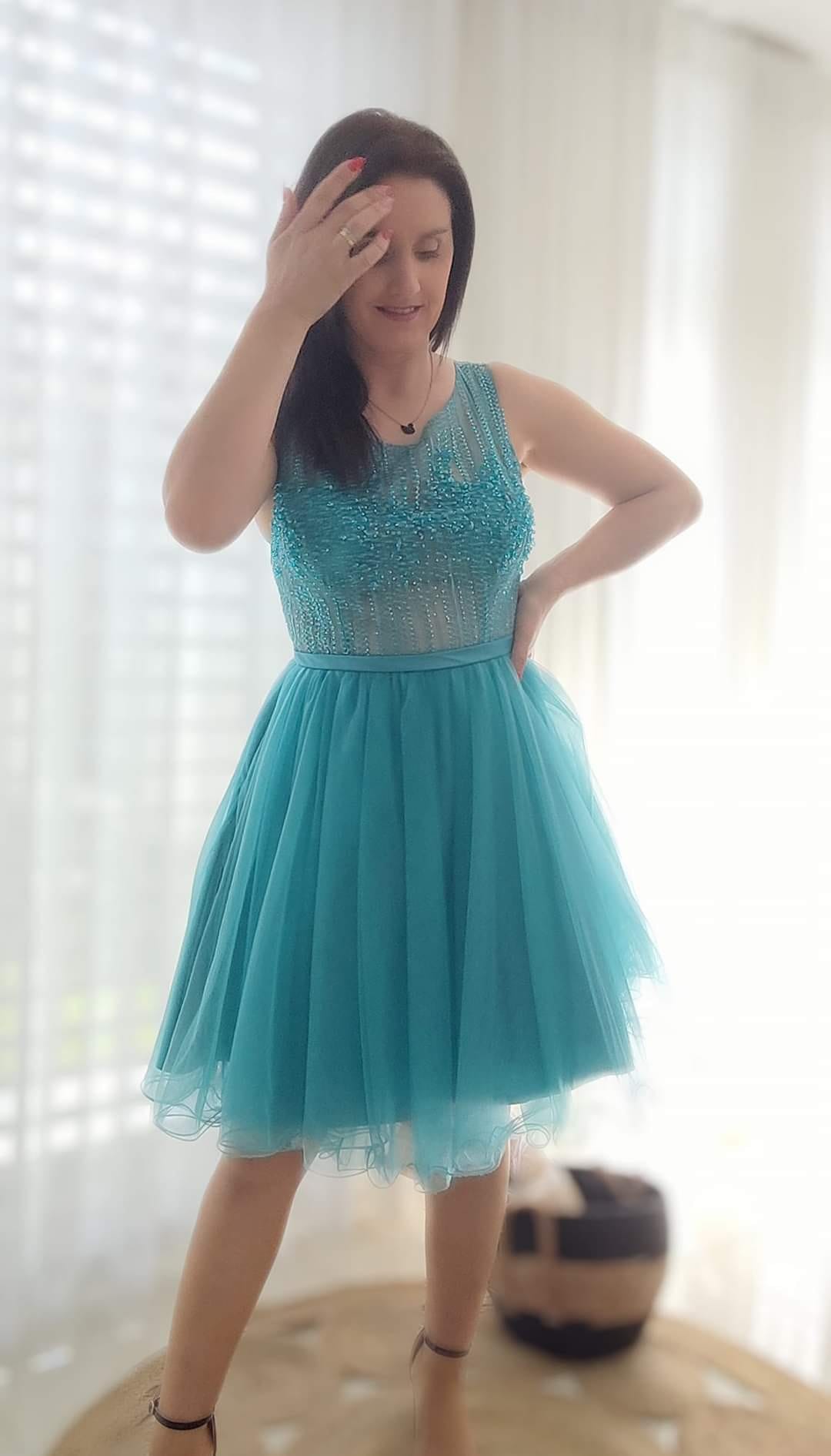 Vestido Princess Mulher a usar vestido azul turquesa com saia rodada e corpo com aplicações brillhantes