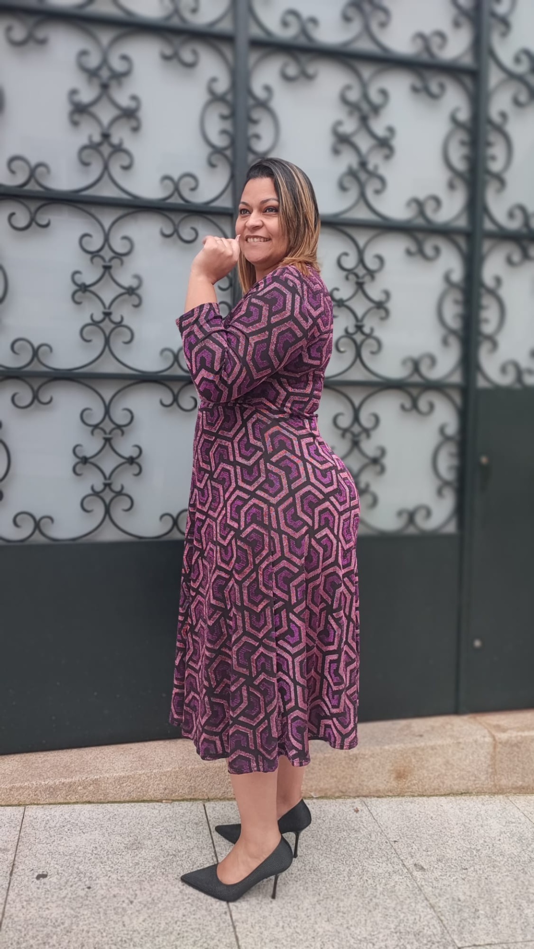 Vestido com padrão e brilho Mulher com vestido midi geométrico rosa e preto e sapatos de salto alto pretos