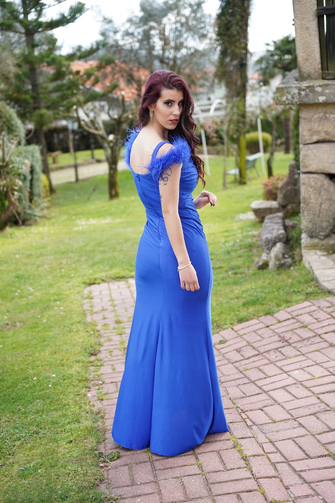 Vestido Valquíria Vestido longo azul com alças de penas usado por mulher em jardim