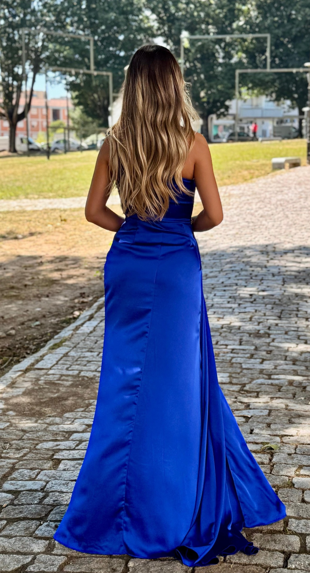 Vestido Mayse Vestido comprido azul royal em tecido acetinado, mulher de costas num parque