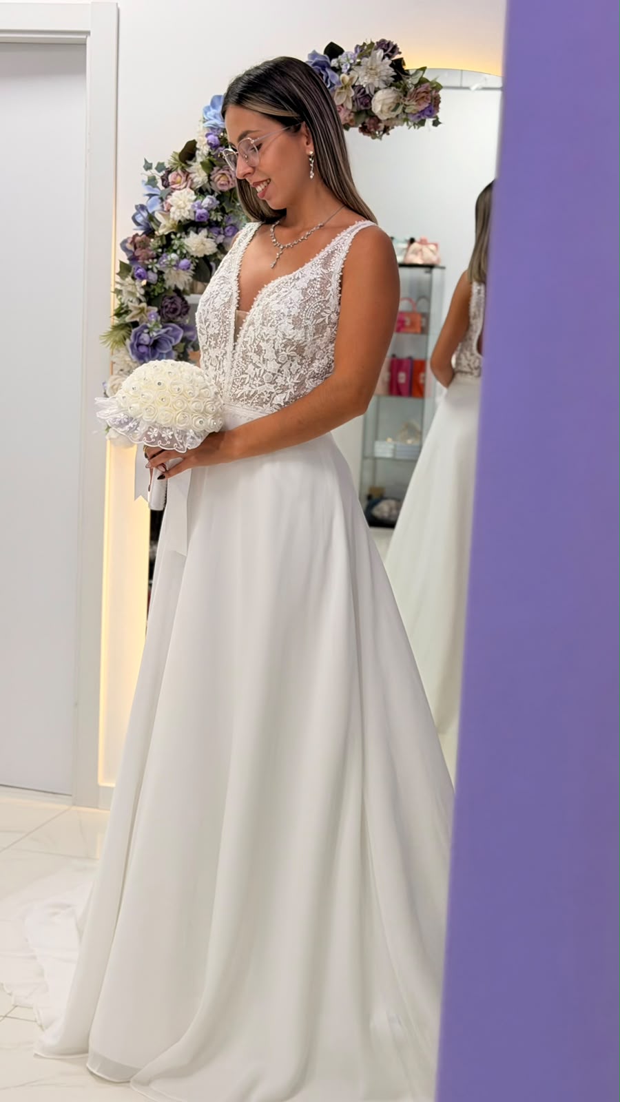 Vestido Miriam Noiva Mulher de vestido de noiva branco com bouquet e decoração floral ao fundo