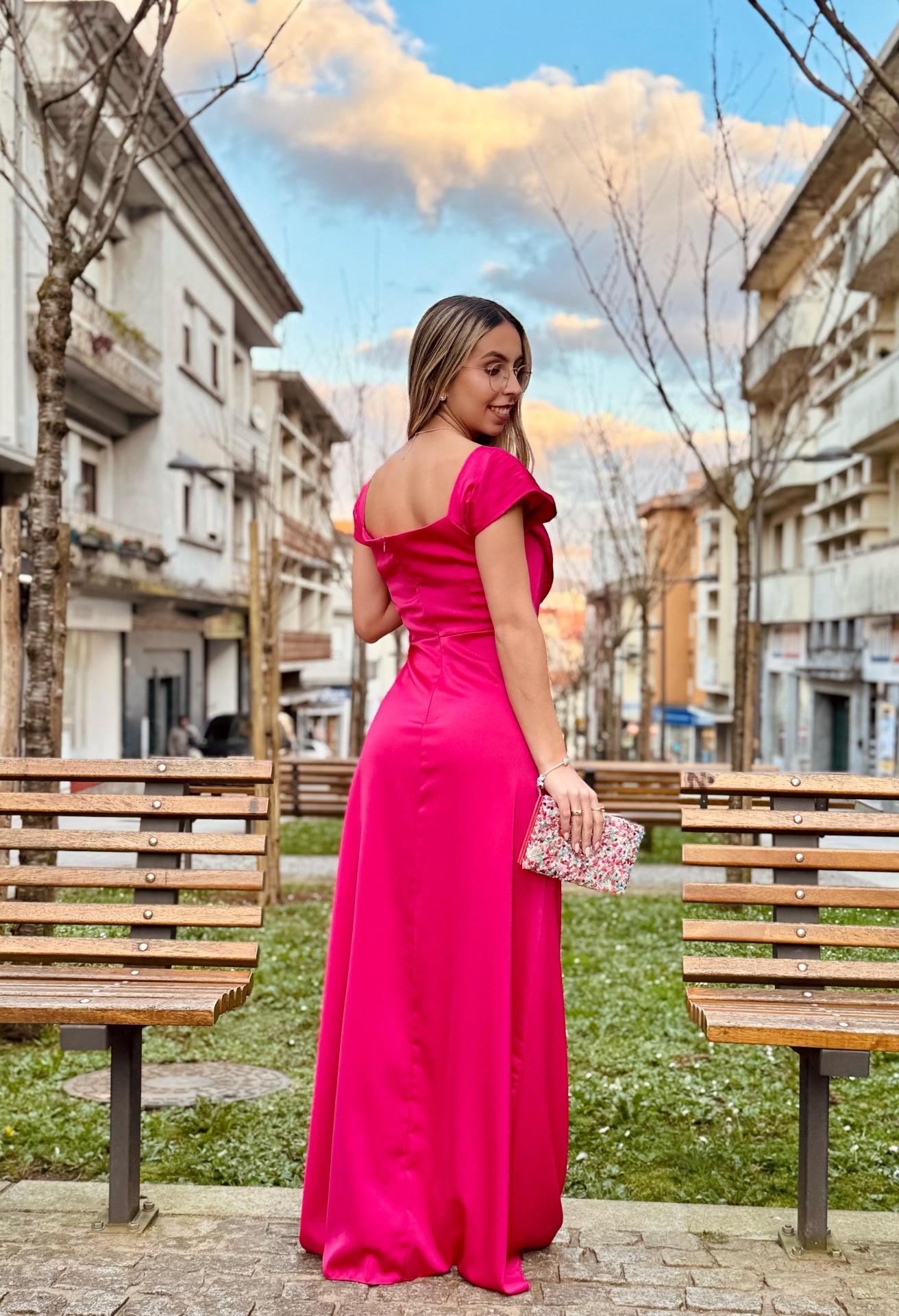 Vestido Sony Vestido comprido rosa fúcsia com carteira floral em ambiente urbano