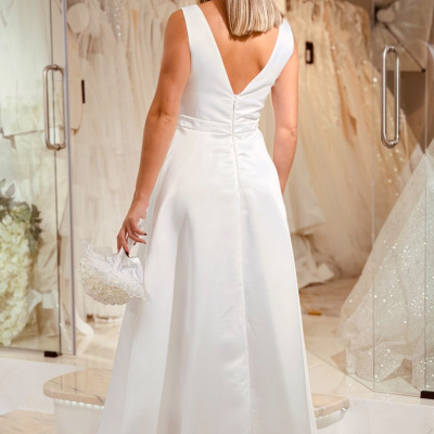 Vestido de noiva branco com decote em V nas costas e sem mangas numa loja