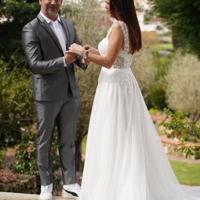 Casal vestido de noivos em cenário exterior