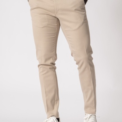 Calças bege com camisa branca e sapatos desportivos brancos