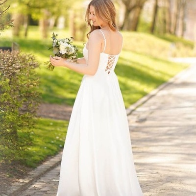 Vestido de noiva branco longo com alças finas e costas amarradas em ambiente natural