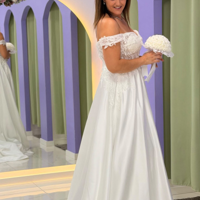 Mulher com vestido de noiva branco em ambiente com espelhos e paredes lilás