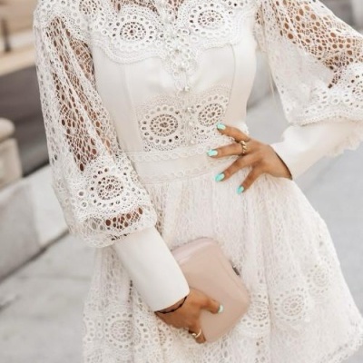 Vestido branco curto de renda com mangas bufantes e padrões circulares