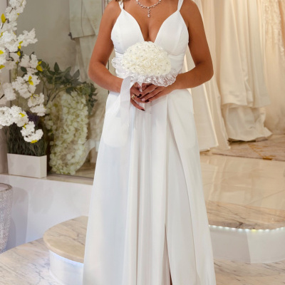 Vestido de noiva branco com alças largas e decote em V com bouquet de flores brancas