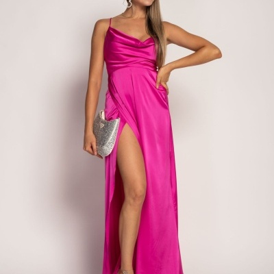 Vestido longo rosa choque com alças finas e fenda lateral alta.