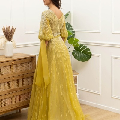 Vestido longo amarelo com mangas bufantes e detalhes brilhantes