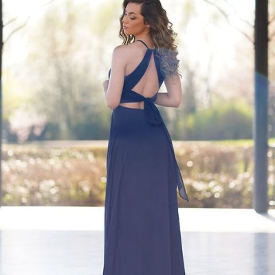 Modelo de costas usando vestido longo azul escuro com alças cruzadas