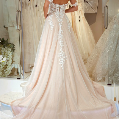 Vestido de noiva rosa claro com detalhes em renda branca e mangas curtas