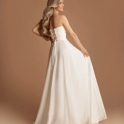 Vestido longo branco com corpete justo e atilhos nas costas.