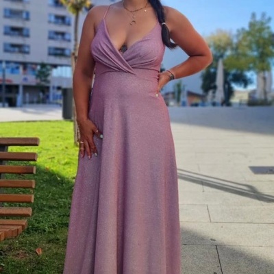 Vestido longo cor de rosa com alças finas e decote em V usado por mulher ao ar livre