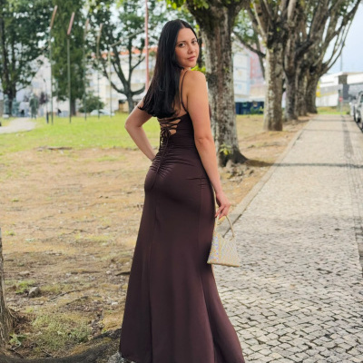 Vestido longo castanho escuro com amarração nas costas e bolsa bege brilhante