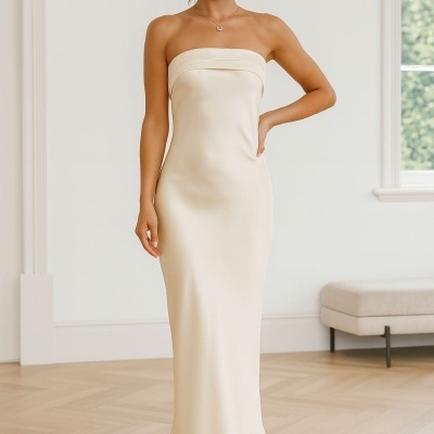 Mulher com vestido longo creme sem alças em ambiente interior