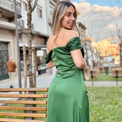 Mulher com vestido verde longo em parque urbano