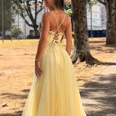 Vestido amarelo claro longo com tiras cruzadas nas costas ao ar livre