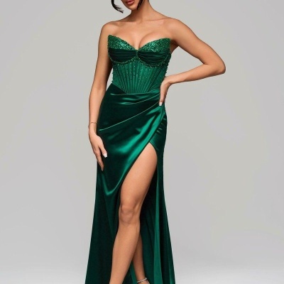 Vestido longo verde esmeralda com corpete decorado e abertura lateral.