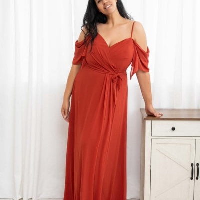 Mulher com vestido comprido vermelho perto de móvel branco