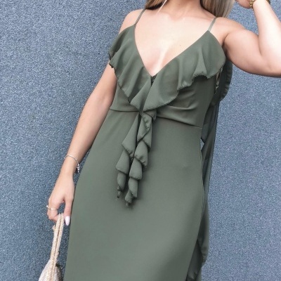 Vestido verde-oliva longo com folhos e alças finas, mala bege texturizada, mulher com óculos e pulseira dourada