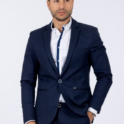 Homem com fato azul escuro e camisa branca com detalhes azul