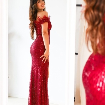 Vestido vermelho longo de lantejoulas com detalhes em penas