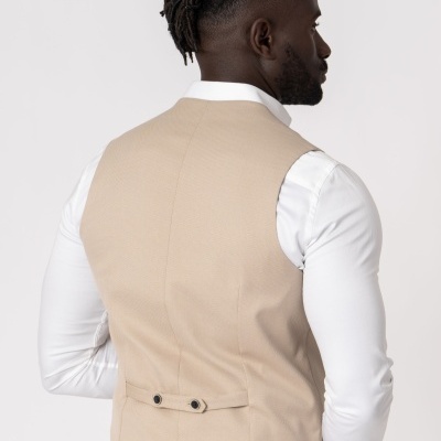 Homem de costas com colete bege e camisa branca